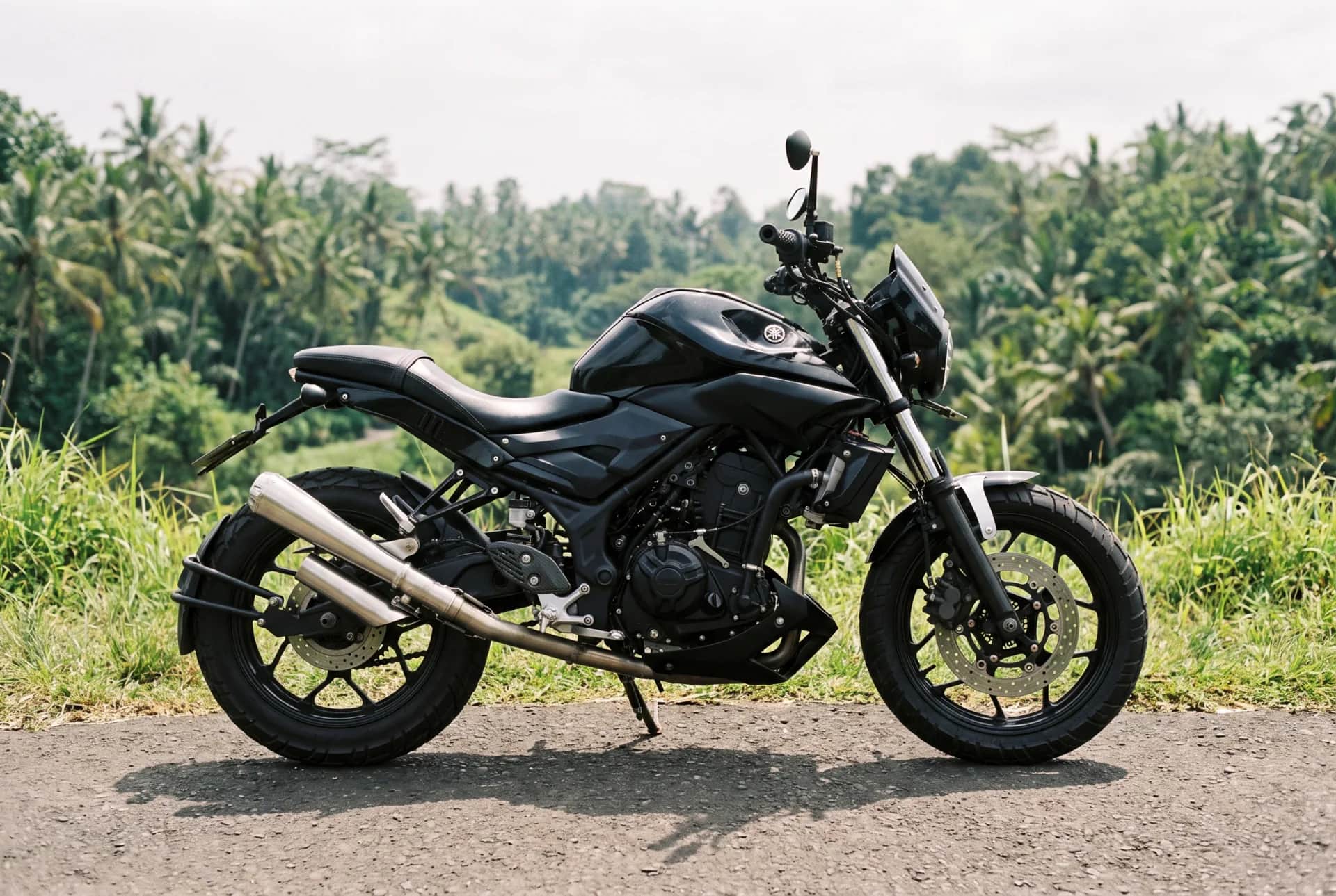 Side profile of the custom Yamaha MT-25 scrambler beside Bali rice fields