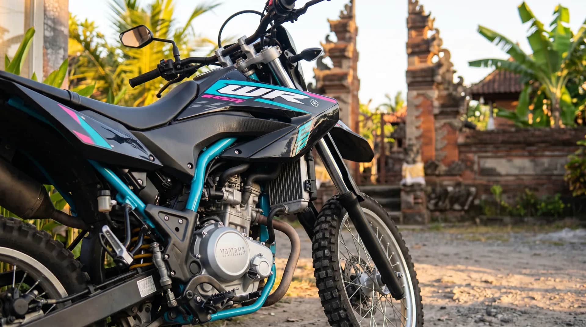 Close-up of the Yamaha WR155's front end and WR graphics by a Balinese temple gate